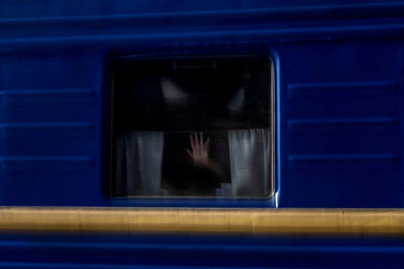 A woman puts her hand over the window of a train as she evacuates from war-affected areas of eastern Ukraine, amid Russia's invasion of the country, in Pokrovsk, Donetsk region, Ukraine