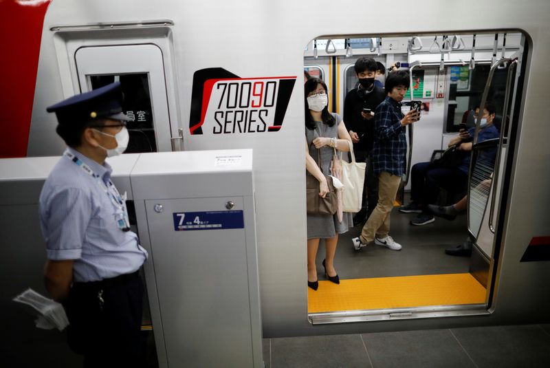 Passengers wearing protective face masks are seen inside the TH Liner, amid the coronavirus disease (COVID-19) outbreak, at Tokyo Metro's newly-opened Toranomon Hills Station in Tokyo
