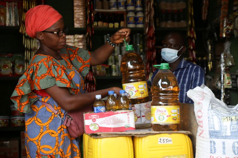 FILE PHOTO: Djeneba Belem a fried bean cakes seller, prepares to buy cooking oil made from palm oil at a shop in Abidjan