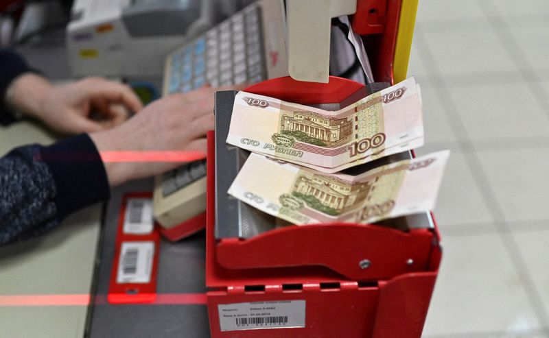 FILE PHOTO: Russian 100-rouble banknotes are placed on a cashier's desk at a supermarket in Tara