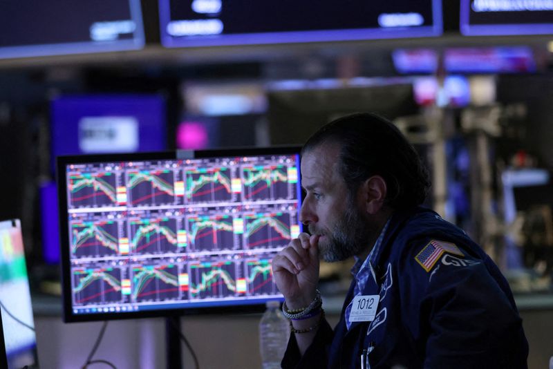 FILE PHOTO: A trader works on the trading floor at the New York Stock Exchange (NYSE) in Manhattan, New York City