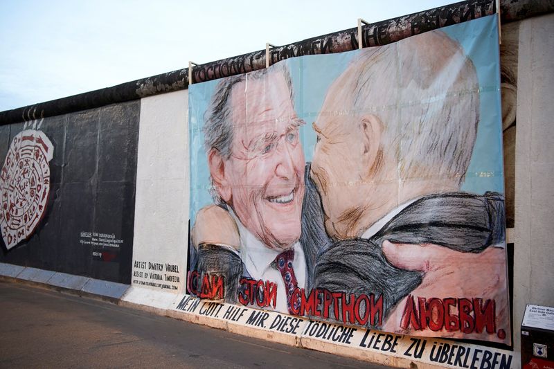 FILE PHOTO: Former German Chancellor Schroeder and Russian President Putin are depicted in a graffiti exchanging a kiss at Berlin's East Side Gallery