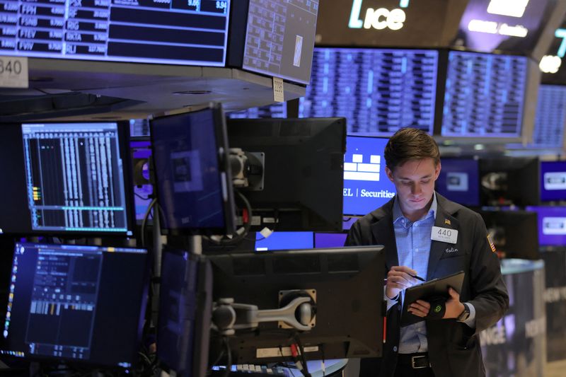 FILE PHOTO: A trader works on the trading floor at the New York Stock Exchange (NYSE) in Manhattan, New York City