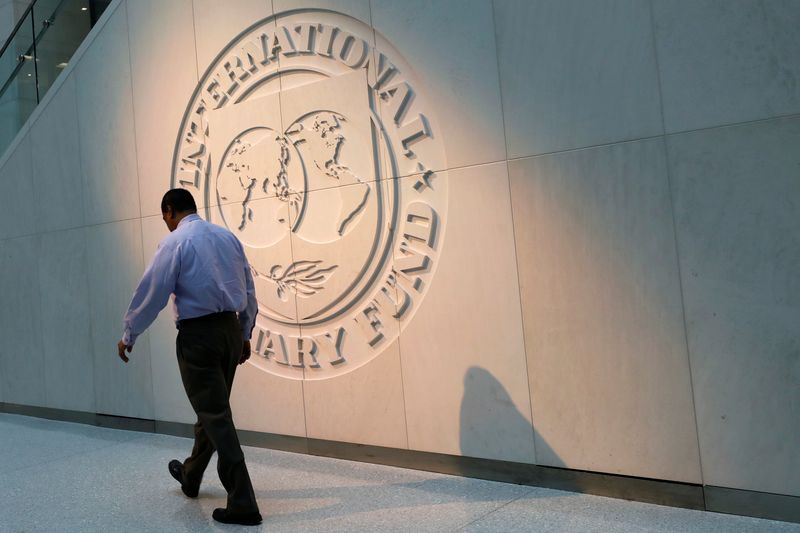FILE PHOTO: Man walks past the IMF logo at HQ in Washington