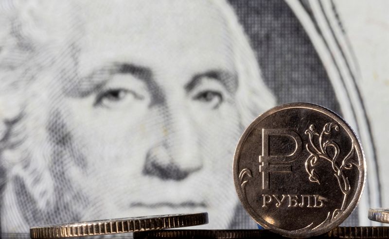 FILE PHOTO: Illustration shows Russian Rouble coins are seen in front of displayed U.S. Dollar banknote