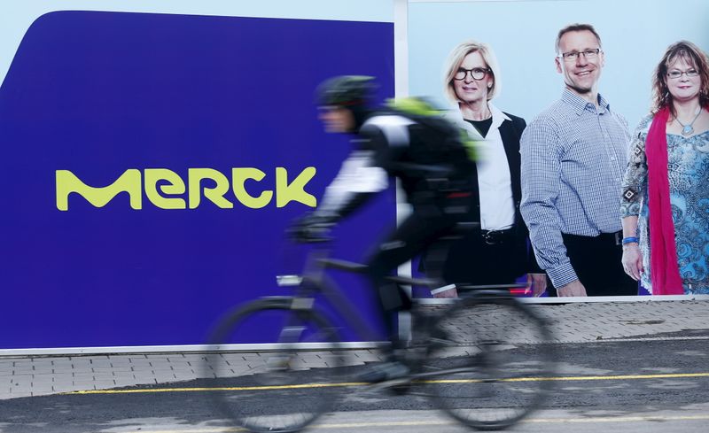 A cyclist drives past a logo of drugs and chemicals group Merck KGaA in Darmstadt