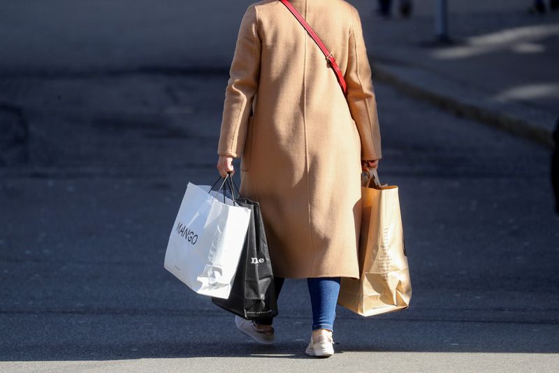 FILE PHOTO: A shopper carries bags after the Swiss government relaxed some of its COVID-19 restrictions, in Zurich