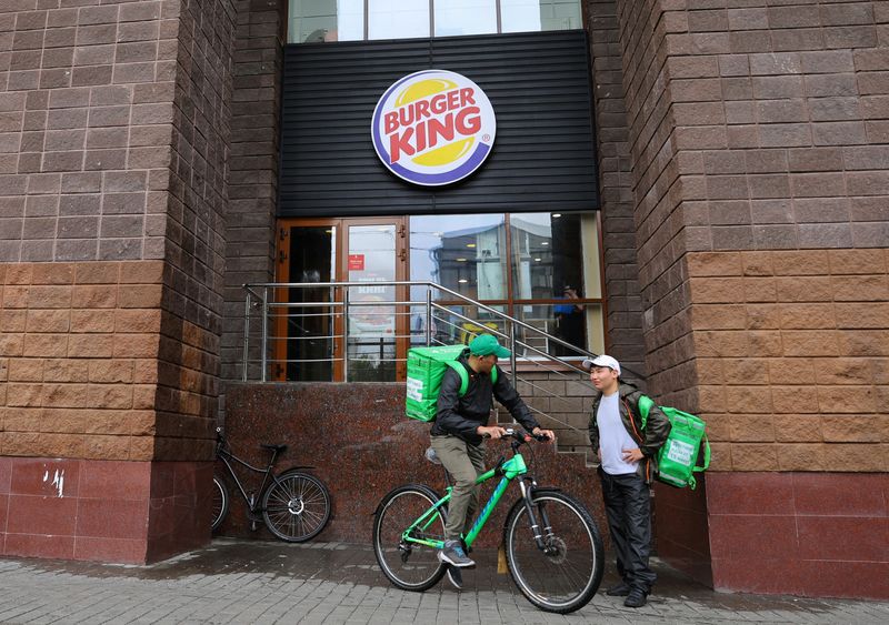 Food delivery couriers are seen outside a Burger King restaurant in Moscow