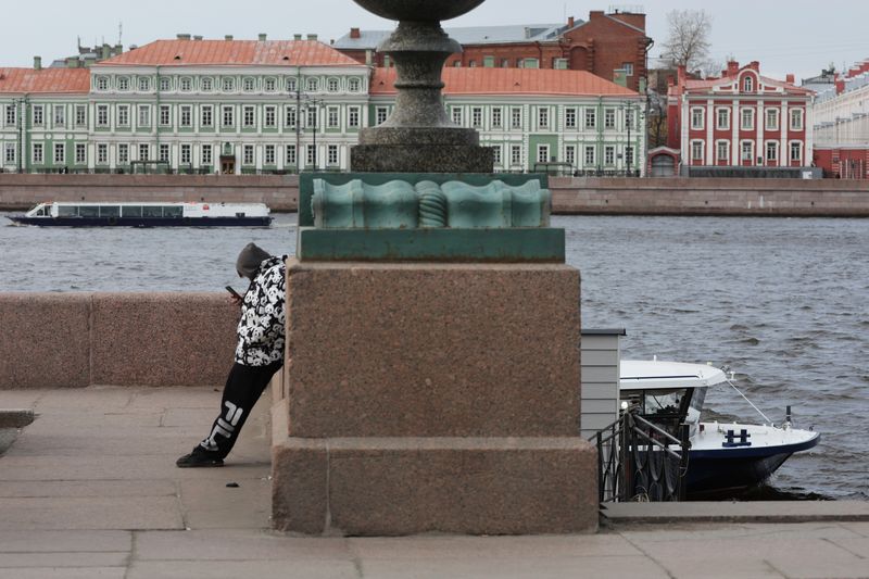 Una persona con un móvil junto al río Neva en San Petersburgo
