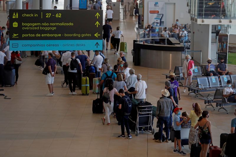FILE PHOTO: People wait in queues at Faro airport amid the coronavirus disease (COVID-19) pandemic, in Faro
