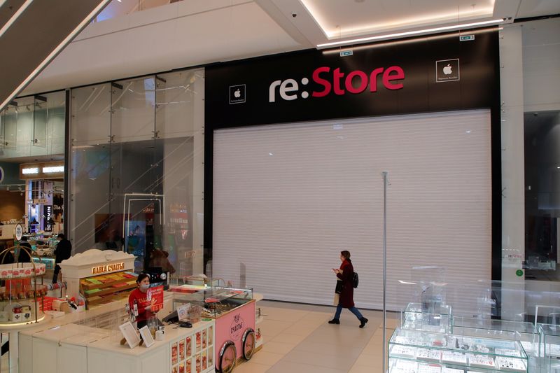 FILE PHOTO: A woman walks past a closed 're:Store', an Apple reseller shop at a mall in Saint Petersburg