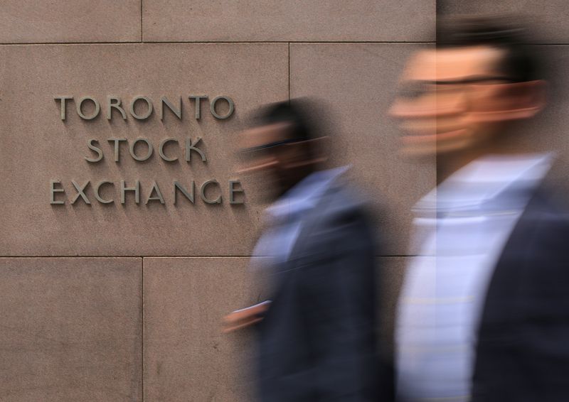 Businessmen pass the Toronto Stock Exchange sign in Toronto