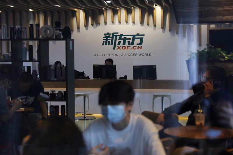 FILE PHOTO: People sit at a cafe inside the headquarters of New Oriental Education & Technology in Beijing