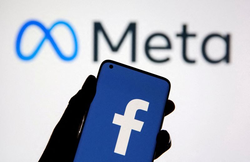 FILE PHOTO: A smartphone with Facebook's logo is seen in front of displayed Facebook's new rebrand logo Meta in this illustration