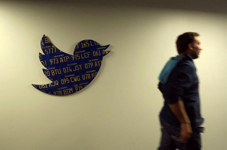 FILE PHOTO: An employee walks past a Twitter logo made from Californian license plates at the company's headquarters in San Francisco