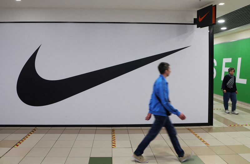 FILE PHOTO: People walk past a closed store of Nike in Saint Petersburg