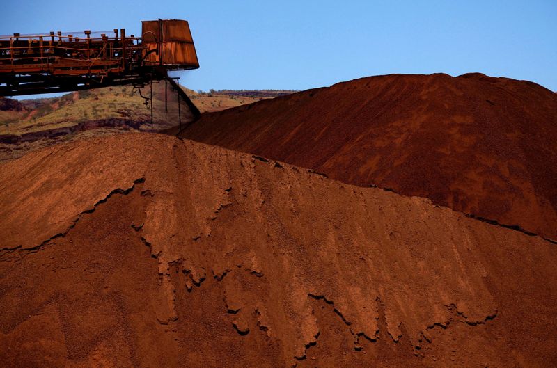 FILE PHOTO: FILE PHOTO: A stacker unloads iron ore onto a pile at a mine located in the Pilbara region of Western Australia