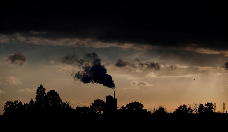 FILE PHOTO: Smoke rises above a factory at sunset in Rugby