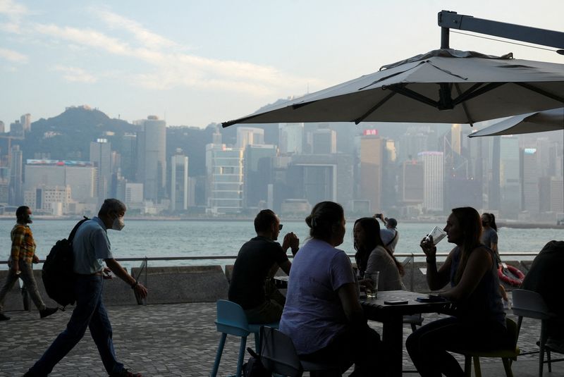FILE PHOTO: People dine at a restaurant nearby Victoria Harbour after the government eased the coronavirus disease (COVID-19) restrictions on businesses, in Tsim Sha Tsui district in Hong Kong