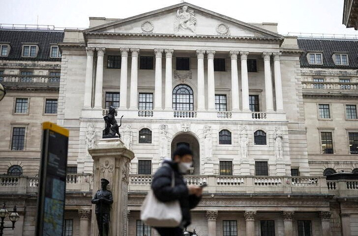 FILE PHOTO: A person walks past the Bank of England in the City of London financial district in London