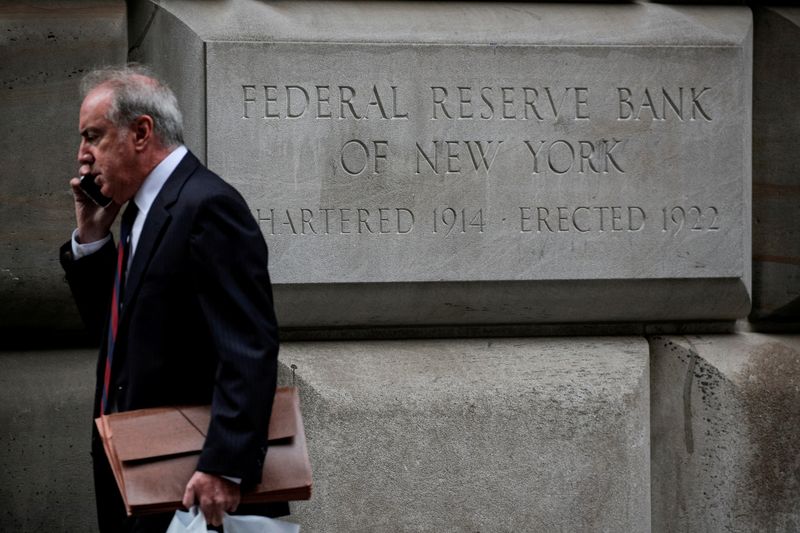 FILE PHOTO: A man walks outside The Federal Reserve Bank of New York