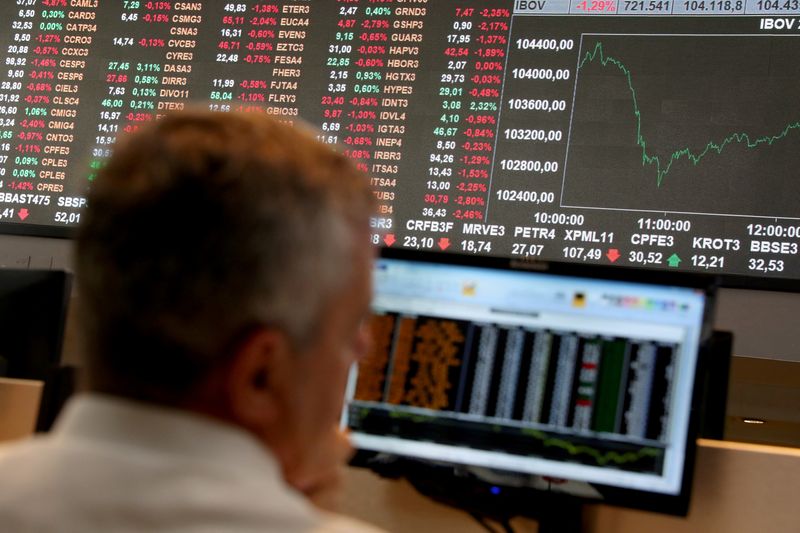 FILE PHOTO: An electronic board showing the graph of the recent fluctuations of market indices is seen as a man works on the floor of Brazil's B3 Stock Exchange in Sao Paulo