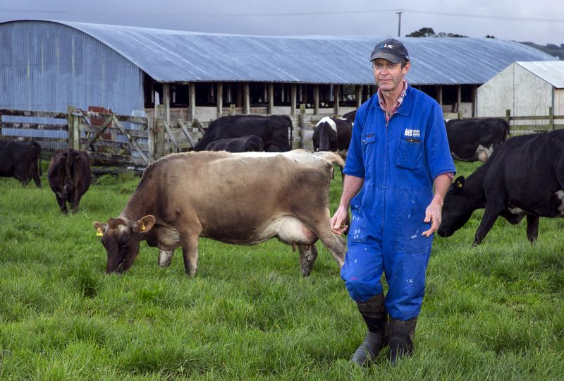 FILE PHOTO: Dairy farmer Keith Trotter stands in a field near milking sheds amongst his herd of cows on his farm in the town of Matakana, located north of Auckland, New Zealand