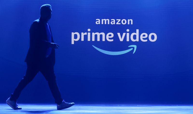 A man walks past a logo of Amazon Prime Video during a launch event in Mumbai