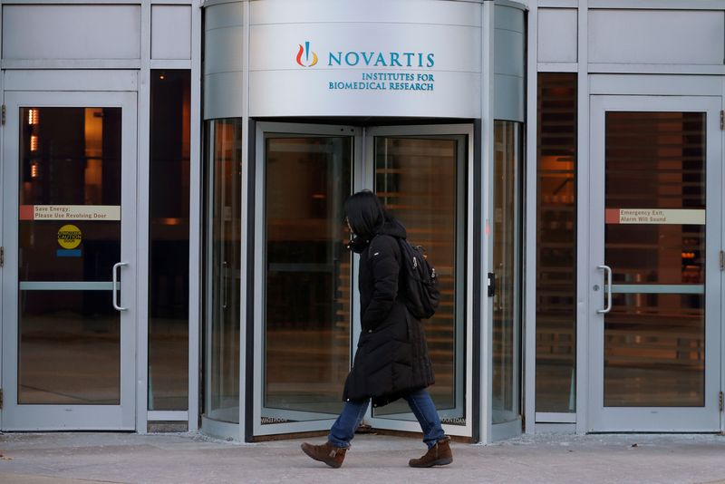 A pedestrian passes Novartis' Institutes for Biomedical Research in Cambridge