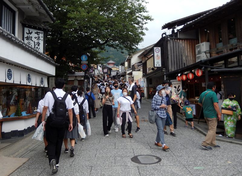 People stroll near Kiyomizu-dera temple, a popular attraction among tourists, in Kyoto
