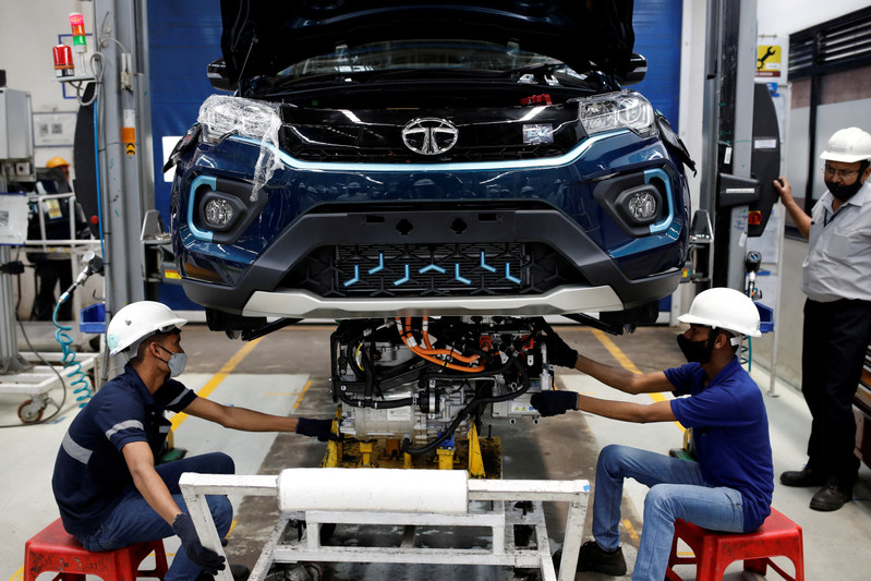 FILE PHOTO: Workers install the electric motor inside a Tata Nexon electric sport utility vehicle (SUV) at the Tata Motors plant in Pune