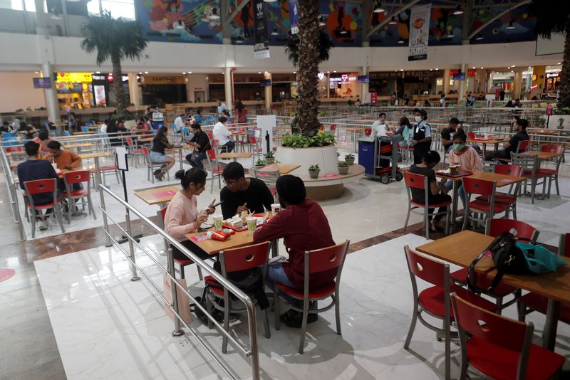 People eat at a food court at a mall after they reopened amidst the spread of the coronavirus disease (COVID-19) in Mumbai