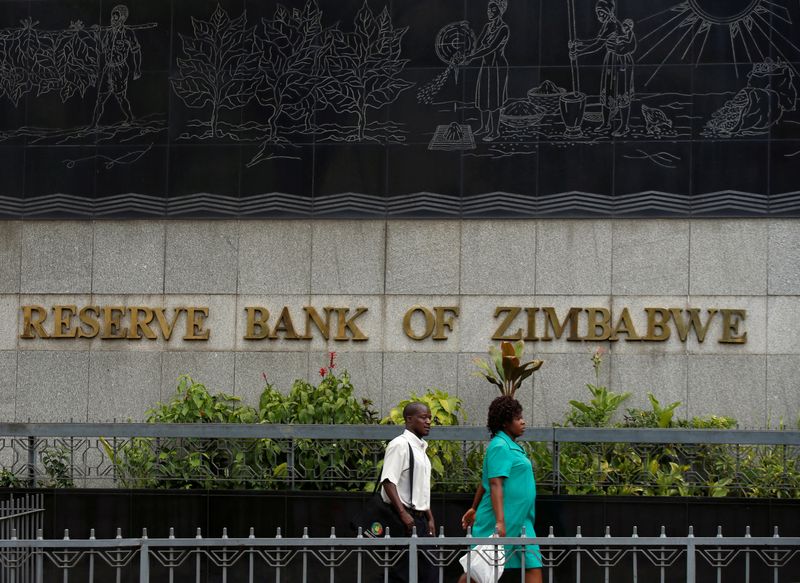 FILE PHOTO: People walk past the Reserve Bank of Zimbabwe building in Harare