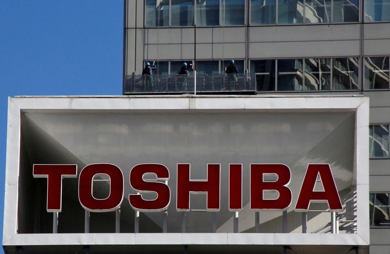 FILE PHOTO: Logo of Toshiba Corp is seen as Window cleaners work on the company's headquarters in Tokyo