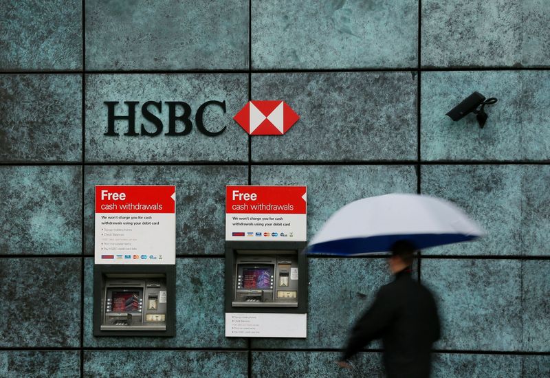FILE PHOTO: A man walks past a HSBC bank branch in the City of London