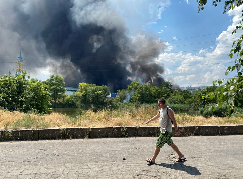 El humo se eleva desde un centro automotriz luego de los recientes bombardeos durante el conflicto entre Ucrania y Rusia en Donetsk, Ucrania