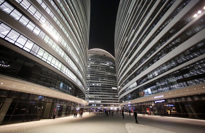 People walk between buildings of Wangjing SOHO on the opening day of the compound, in Beijing
