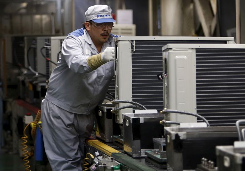 An employee of Daikin Industries Ltd works at the production line of outdoor air conditioning units at the company's Kusatsu factory in Shiga