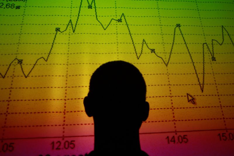FILE PHOTO: Photo illustration of man silhouetted in an electronic board showing the Italian equity market index in Rome