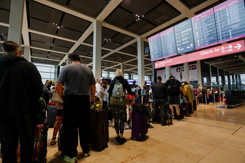 ARCHIV: Passagiere warten in der Schlange am Check-in am Flughafen Berlin Brandenburg (BER), Schönefeld, Deutschland