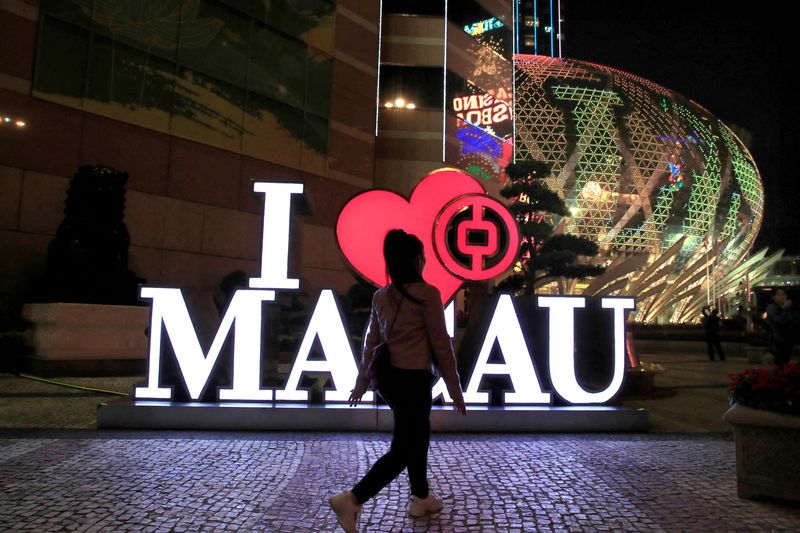 A woman walks past a Bank of China branch next to the Grand Lisboa hotel and casino in Macau