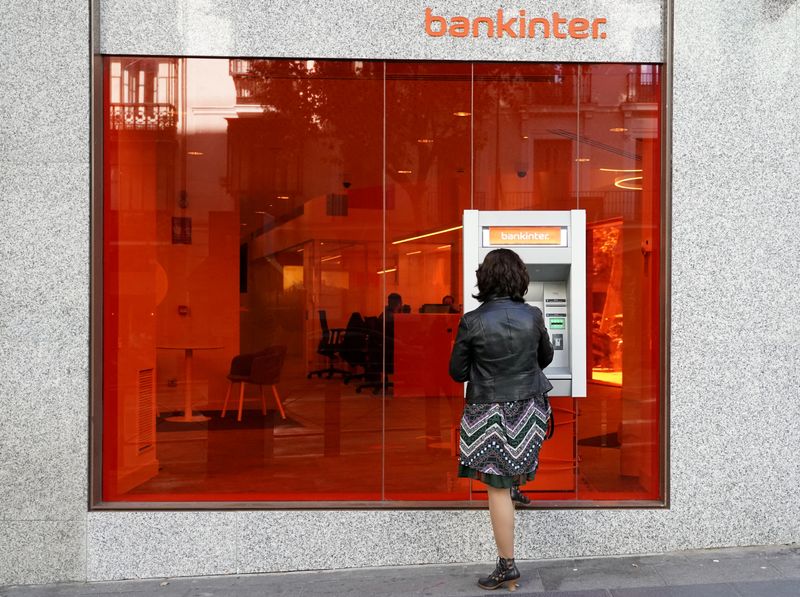 FILE PHOTO: A woman uses ATM machine at Bankinter bank branch in Madrid