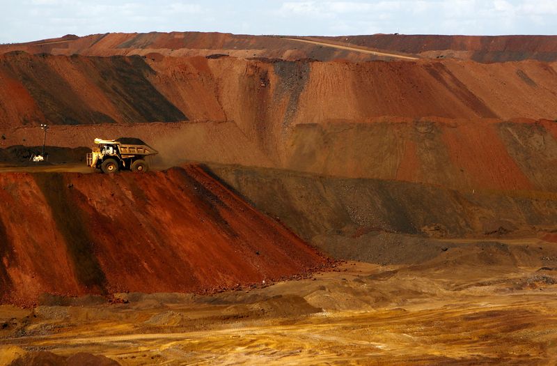 A truck carrying iron ore moves along a road at the Fortescue Metals Group (FMG) Christmas Creek iron ore mine located south of Port Hedland in the Pilbara region of Western Australia