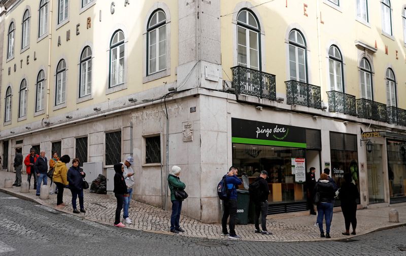 FILE PHOTO: People queue outside of a Pingo Doce supermarket as the spread of the coronavirus disease (COVID-19) continues in downtown Lisbon