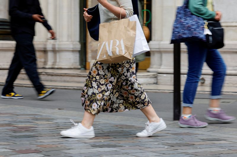 FILE PHOTO: Shopper carries bags as she walks on a street in Paris