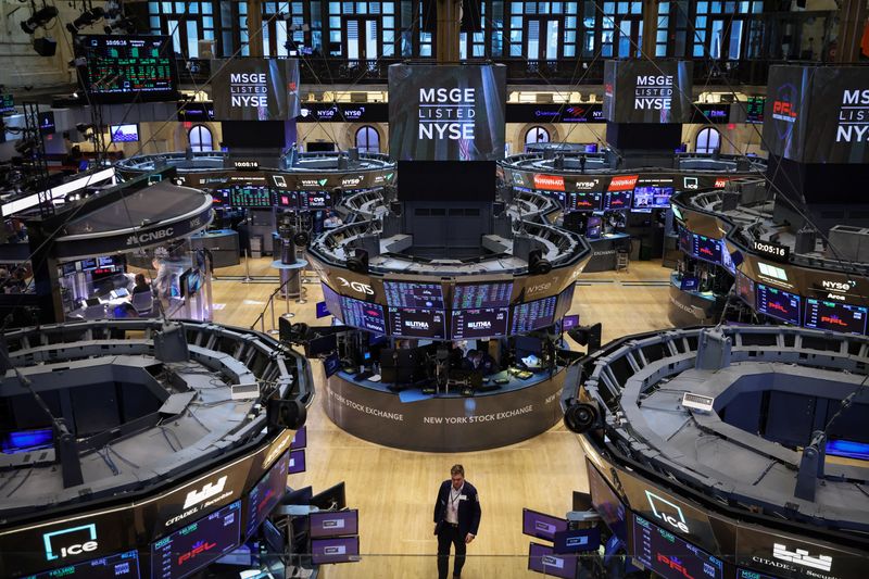 FILE PHOTO: A trader walks on the trading floor at the New York Stock Exchange (NYSE) in Manhattan, New York City