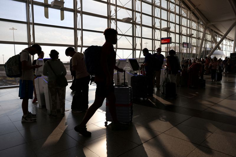 FILE PHOTO - Passengers use self check-in machines as they travel from John F. Kennedy International Airport on the July 4th weekend, in Queens, New York City