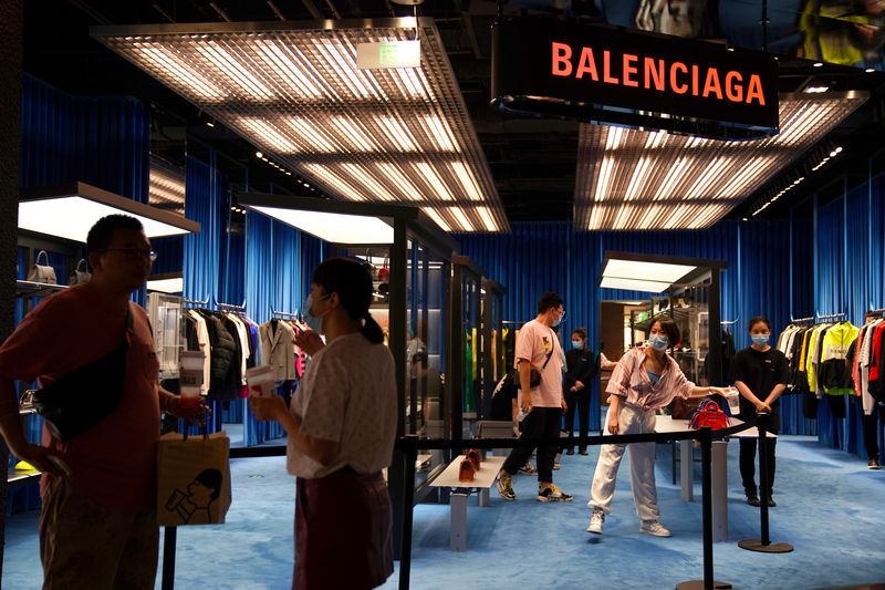 FILE PHOTO: People wearing face masks following the COVID-19 outbreak are seen at a store of French luxury brand Balenciaga inside a shopping mall in Beijing