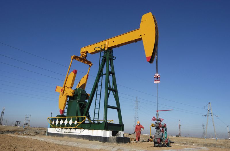 FILE PHOTO - A oil field worker works at a pump jack in PetroChina's Daqing oil field in China's northeastern Heilongjiang province