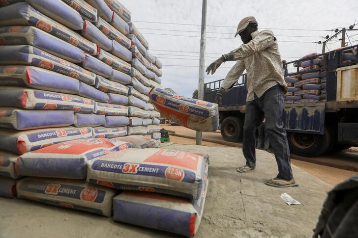 Men offload cement from a truck in Abuja